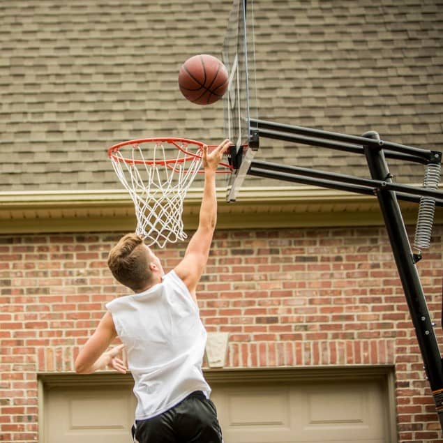A kid playing with a basketball hoop